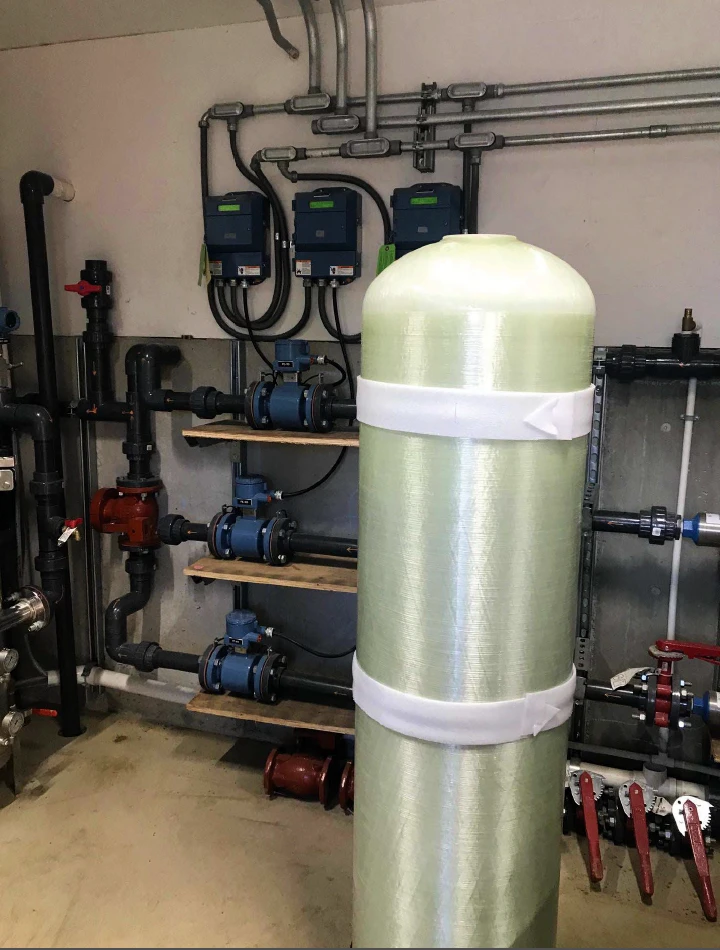 Interior view of the main water treatment facility at C Lazy U Ranch, featuring a large water tank and extensive piping.