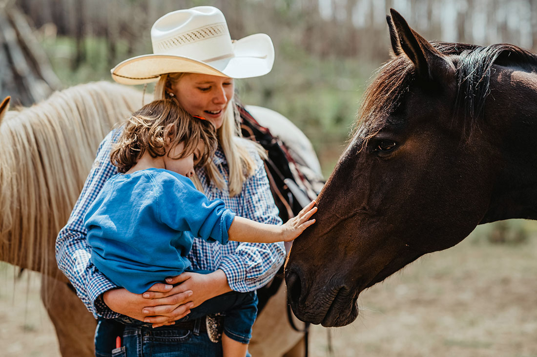 toddler-counselor-caressing-horse